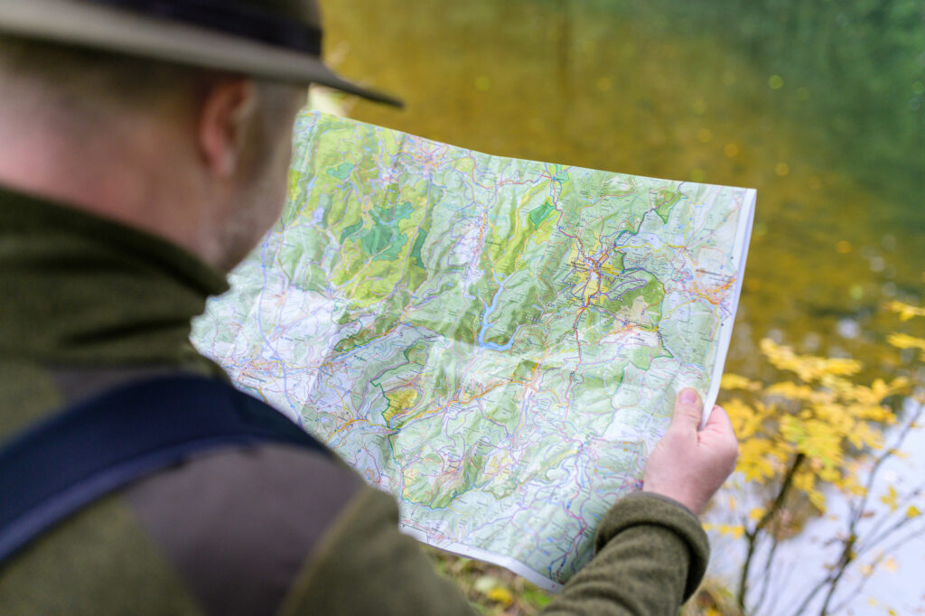 Blick über die Schulter einer Person auf eine Wanderkarte.