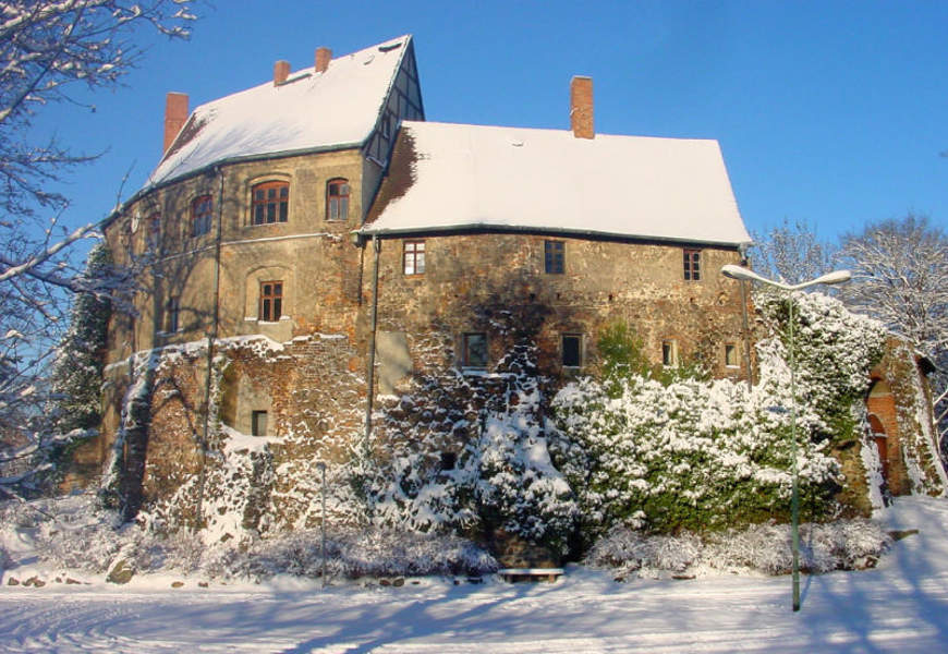 Die Dächer der Burg Roßlau sind vom Schnee bedeckt.