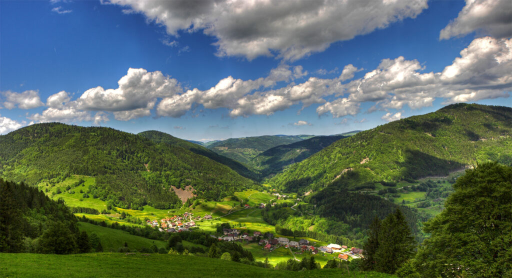 Eine Berg- und Tallandschaft mit Dörfern, Wiesen und Wäldern