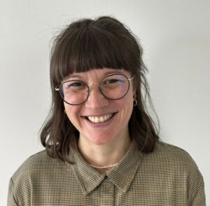 Eine Frau lächelt in die Kamera.