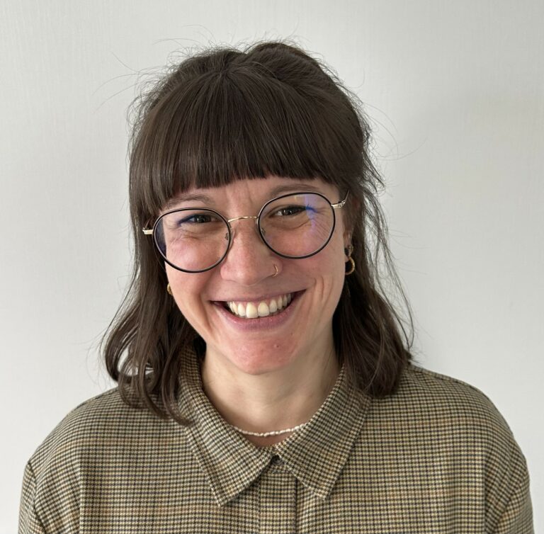 Eine Frau lächelt in die Kamera.